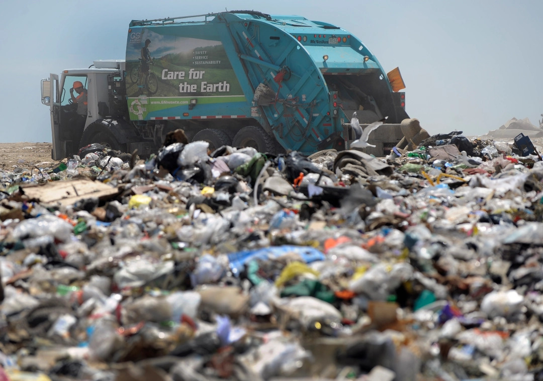 Garbage truck driving through a landfill